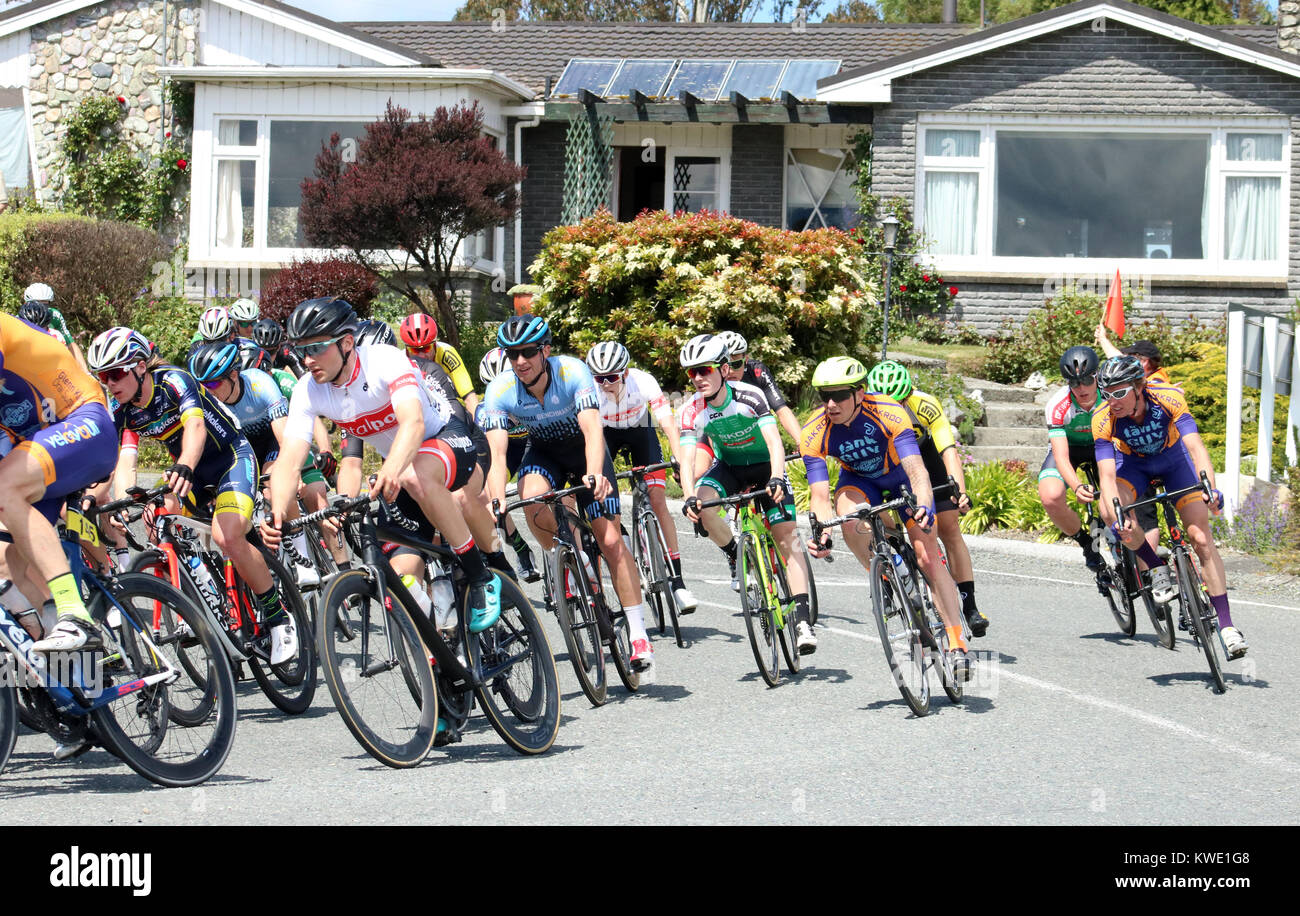 Tour del Southland cycle race passando attraverso Manapouri nell Isola del Sud, Nuova Zelanda mostra impaccato peleton esegue una curva. Foto Stock