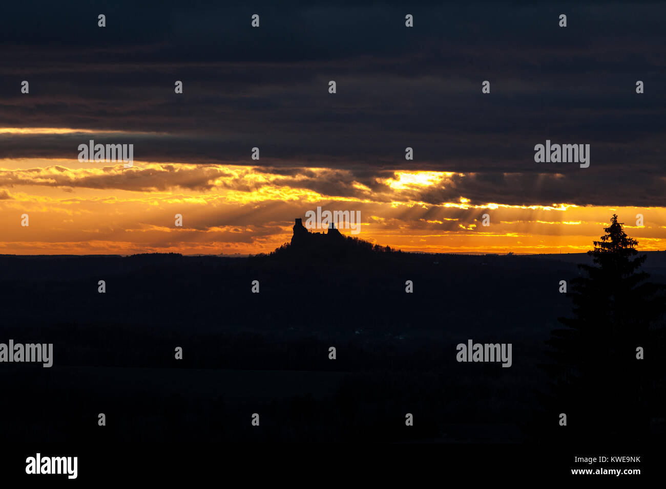 Drammatica ad alto contrasto, nero e blu cielo arancione tramonto sulle rovine del castello di Trosky con un albero, Cesky Raj, Boemia orientale, Repubblica ceca, l'Europa. Foto Stock