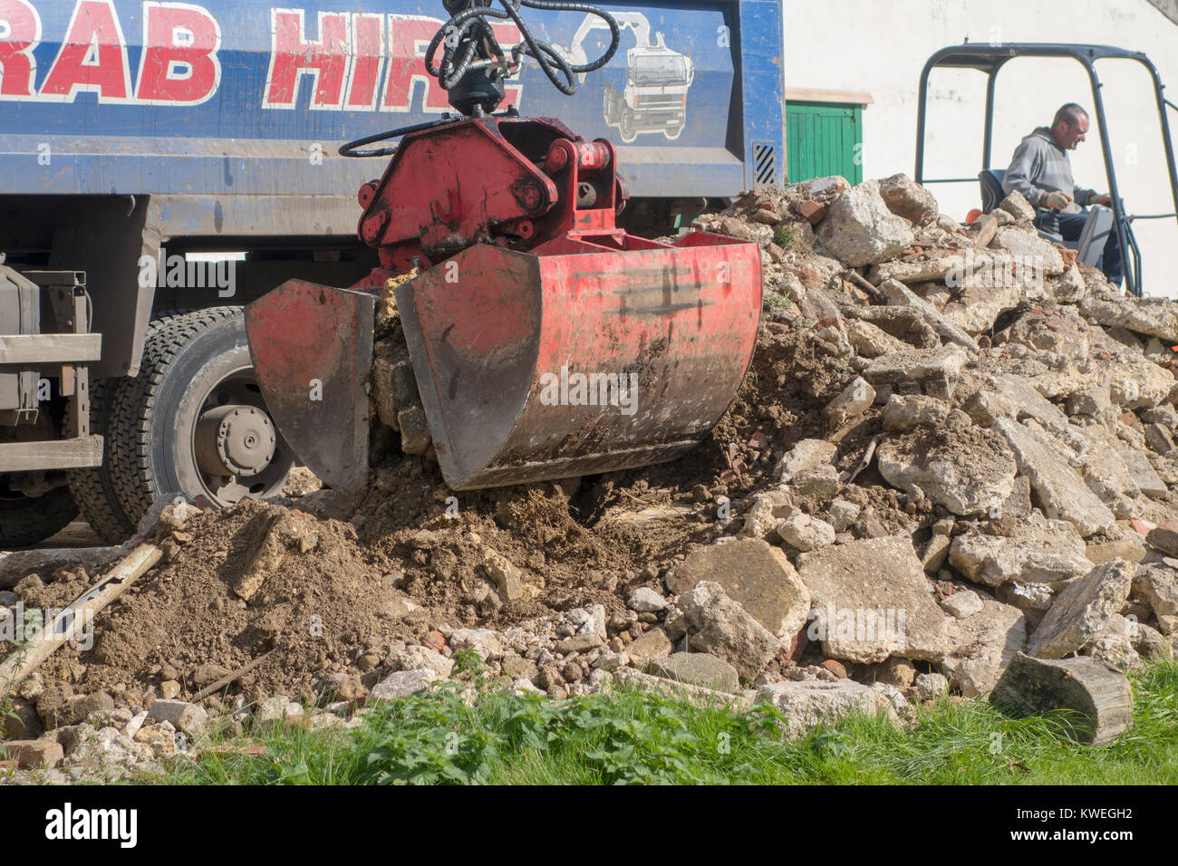 Grab autocarro la raccolta di macerie da un sito di costruzione Foto Stock