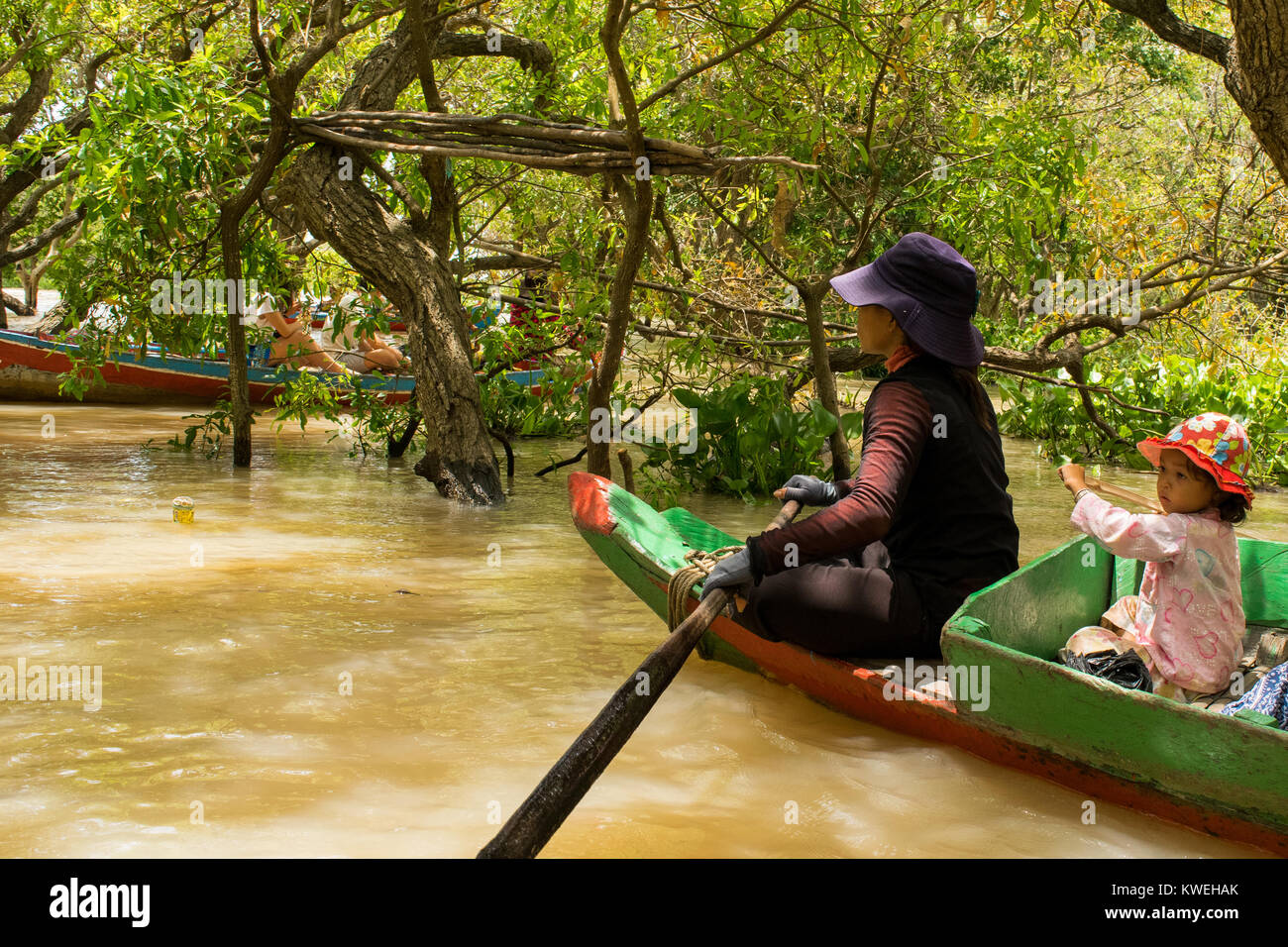 Asian cambogiani donna e giovane figlia paddling una canoa, esplorare la foresta flottante foresta allagata in Kampong Phluk, Lago Tonle Sap Cambogia Foto Stock
