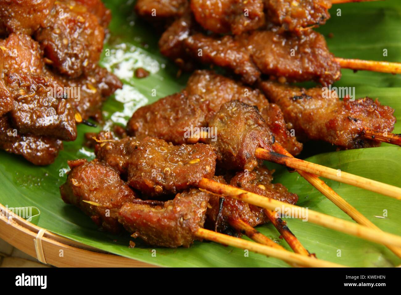 Sate Babi Bali. Balinese di maiale piccante saté; disposti su una foglia di banano. Foto Stock