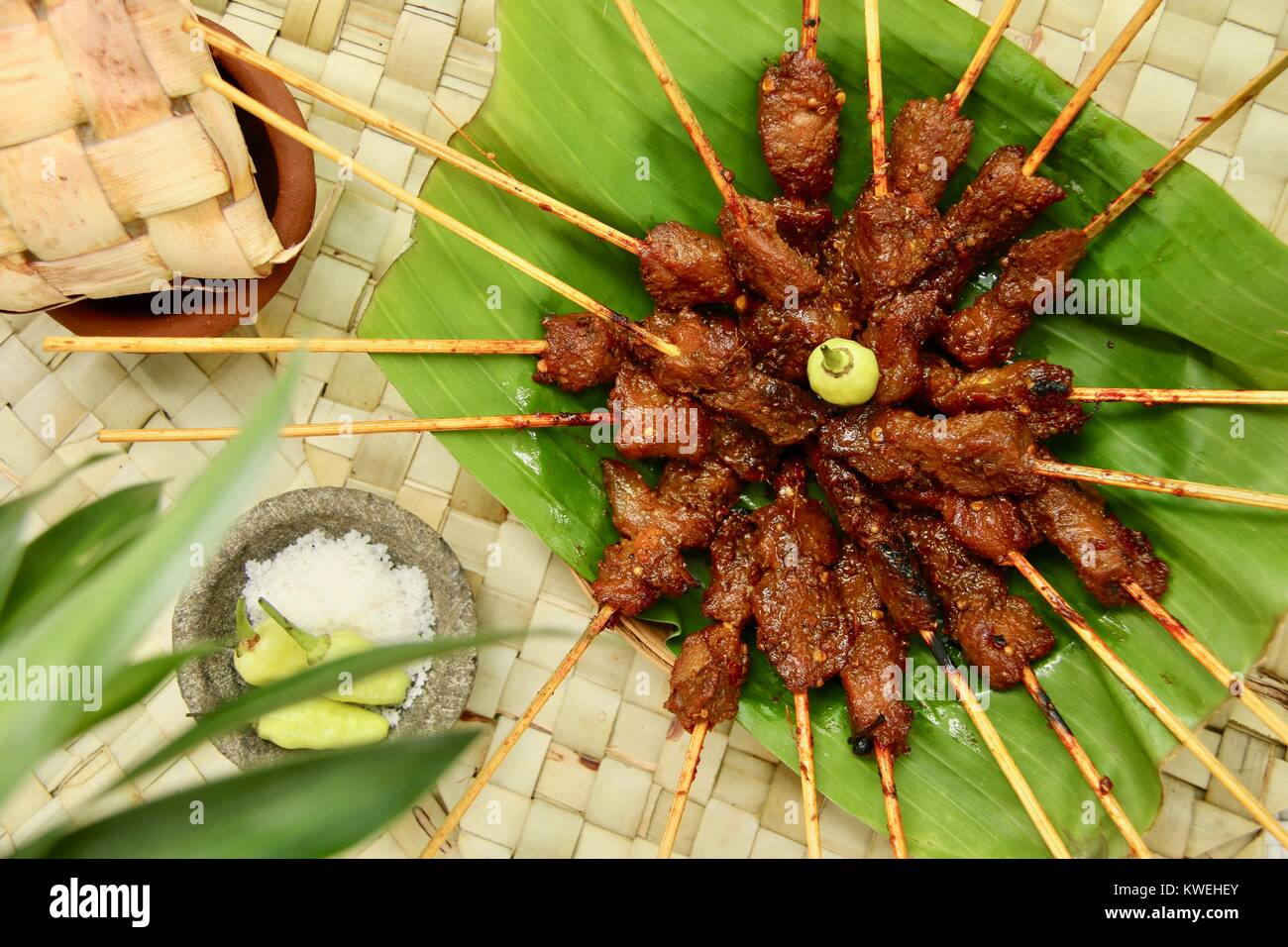 Sate Babi Bali. Balinese di maiale piccante saté, servito con condimento di sale marino e fresco peperoncini verdi. Foto Stock