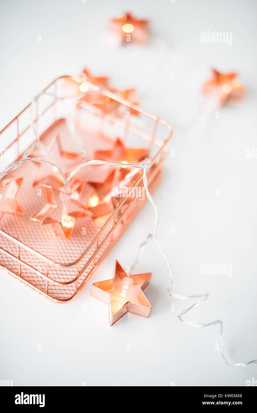 Il rame stelle string luci su sfondo bianco, dettagli di vacanza Foto Stock