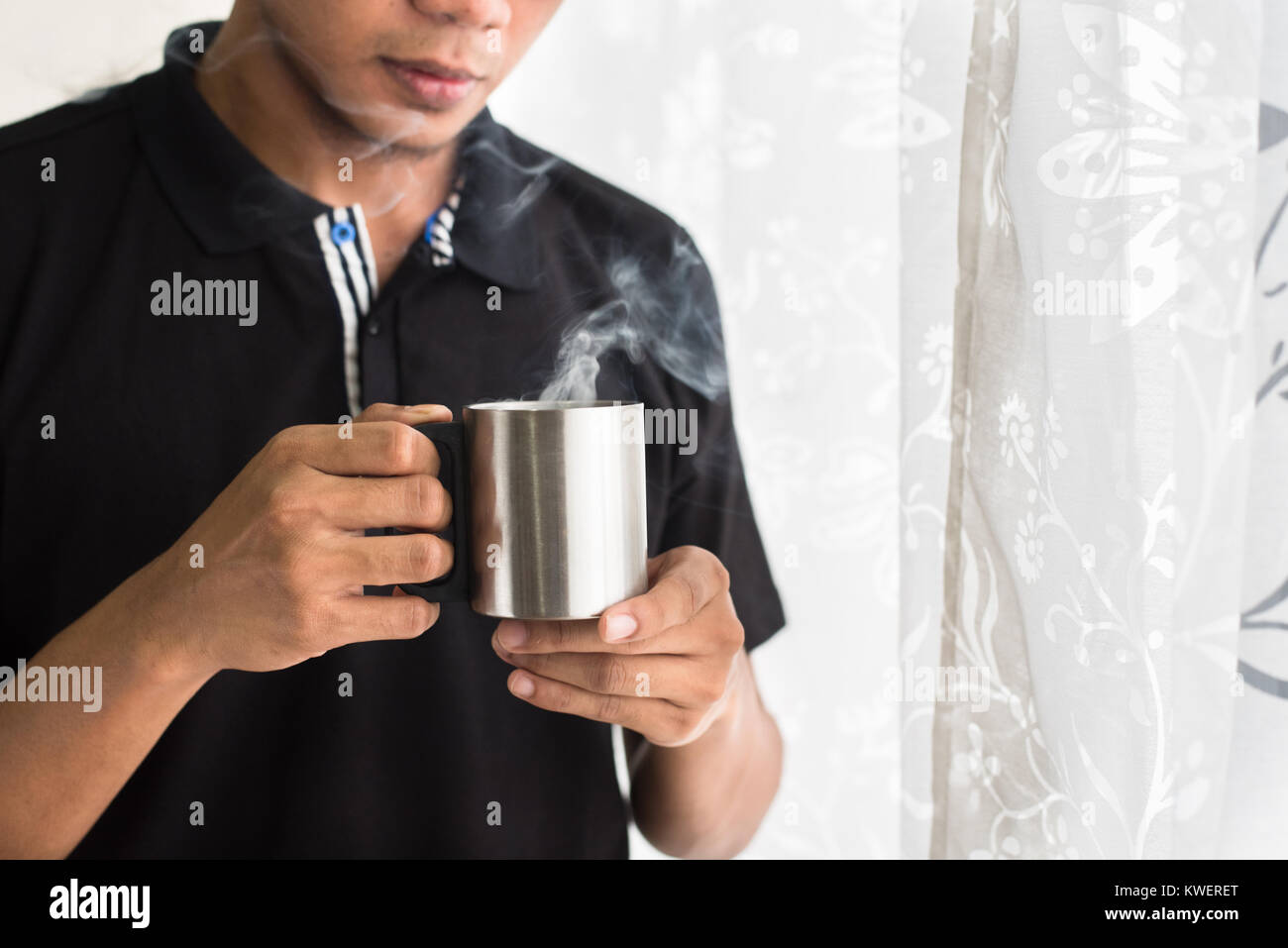 Asian teen tenendo una tazza con bevande calde al mattino. caffè, tè o cioccolata calda in tazza Foto Stock