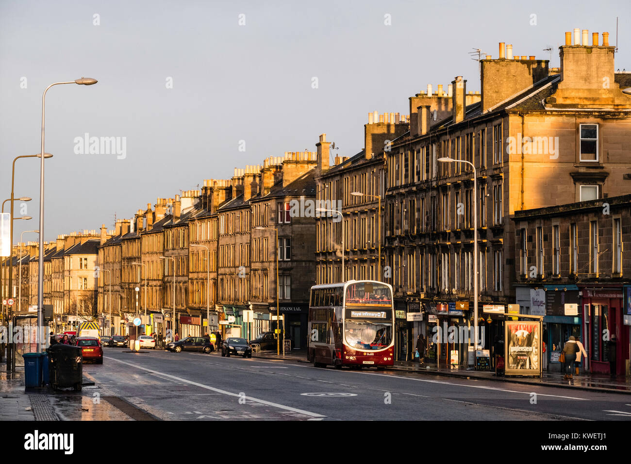 Vista lungo Leith Walk street con tardo pomeriggio inverno luce che risplende su tenement edifici, Edimburgo, Scozia, Regno Unito Foto Stock