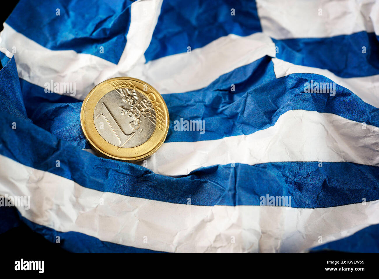 Eurocoin accartocciata sulla bandiera della Grecia, simbolico debito foto litigio, Euromünze auf zerknitterter Griechenlandfahne, Symbolfoto Schuldenstreit Foto Stock