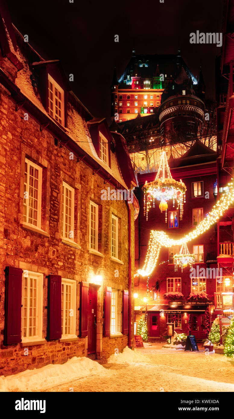 Le decorazioni di Natale e di neve fresca in Quebec City la Petit Champlain zona di notte - Rue Cul de Sac con lo Chateau Frontenac sopra Foto Stock