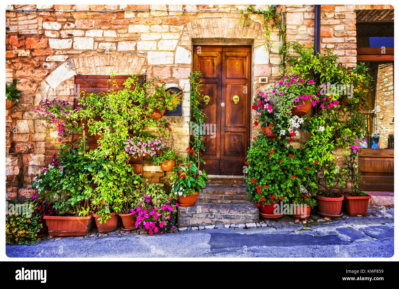 Tradizionale vecchie strade di Spello village,vista con la decorazione floreale,l'Umbria,l'Italia. Foto Stock