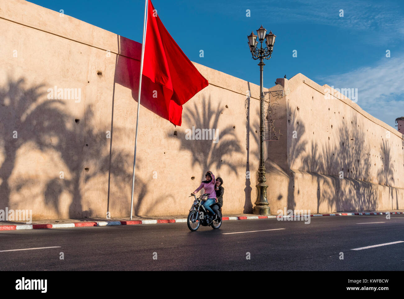 Bandiera marocchina e Medina le mura della città con le ombre di Palm. Foto Stock