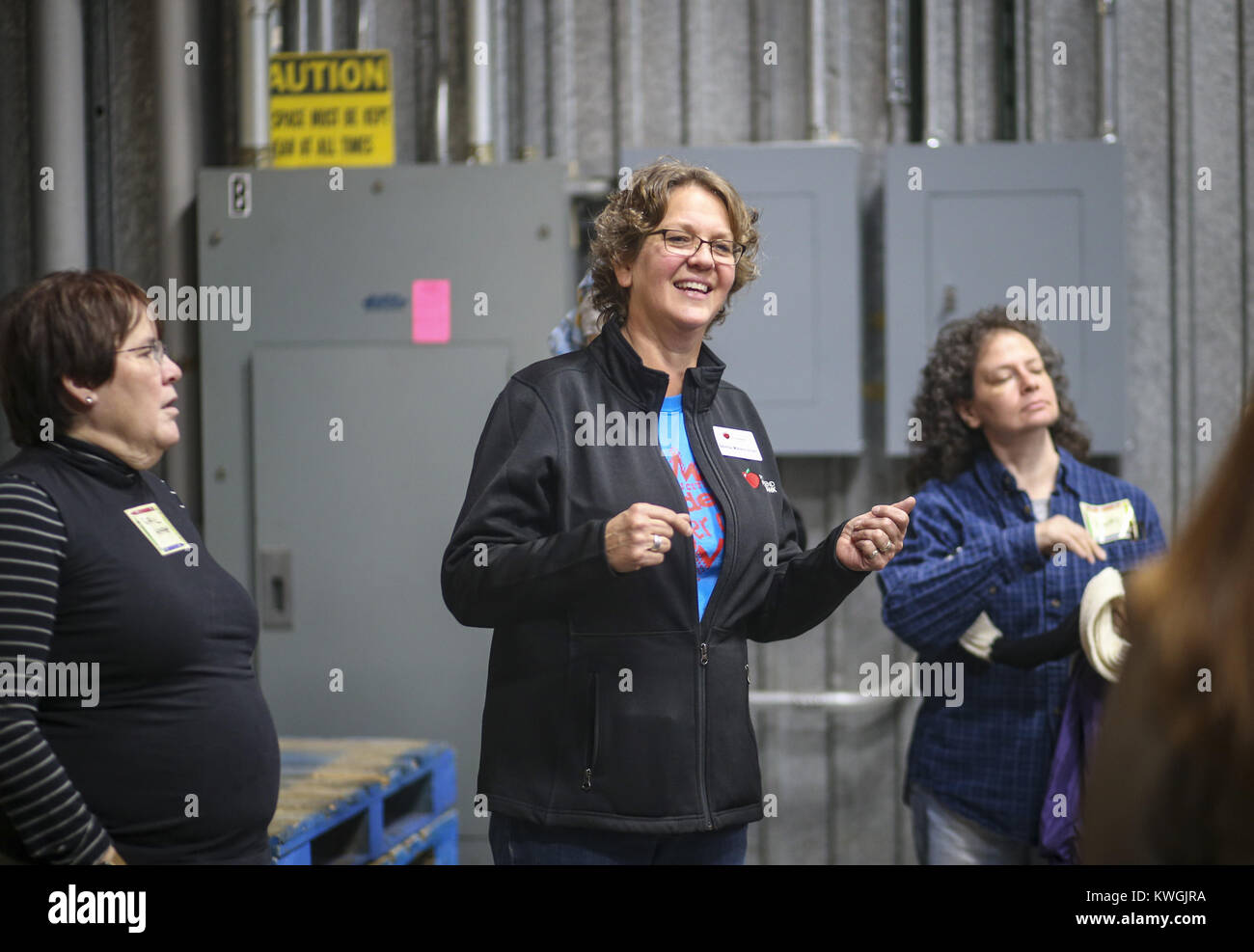 Davenport, Iowa, USA. 4° dic, 2017. Coordinatori volontari Belinda Mielenhausen parla ai volontari di ansa del fiume Foodbank a Davenport lunedì 4 dicembre 2017. Il capitolo locale della Fraternità di Salaam Shalom ha preso parte ad un evento nazionale di solidarietà portando American Jewish e donne musulmane insieme per eseguire gli atti di carità insieme come una parte del National Sadaqah-Tzedakah giorno. Il Capitolo ha scelto di concentrarsi sulla fame insicurezza come la loro attenzione per questo anno di progetto e ha lavorato per confezionare sacchetti di cibo per i bambini da portare a casa per il fine settimana mentre la scuola è in sessione. (Credi Foto Stock