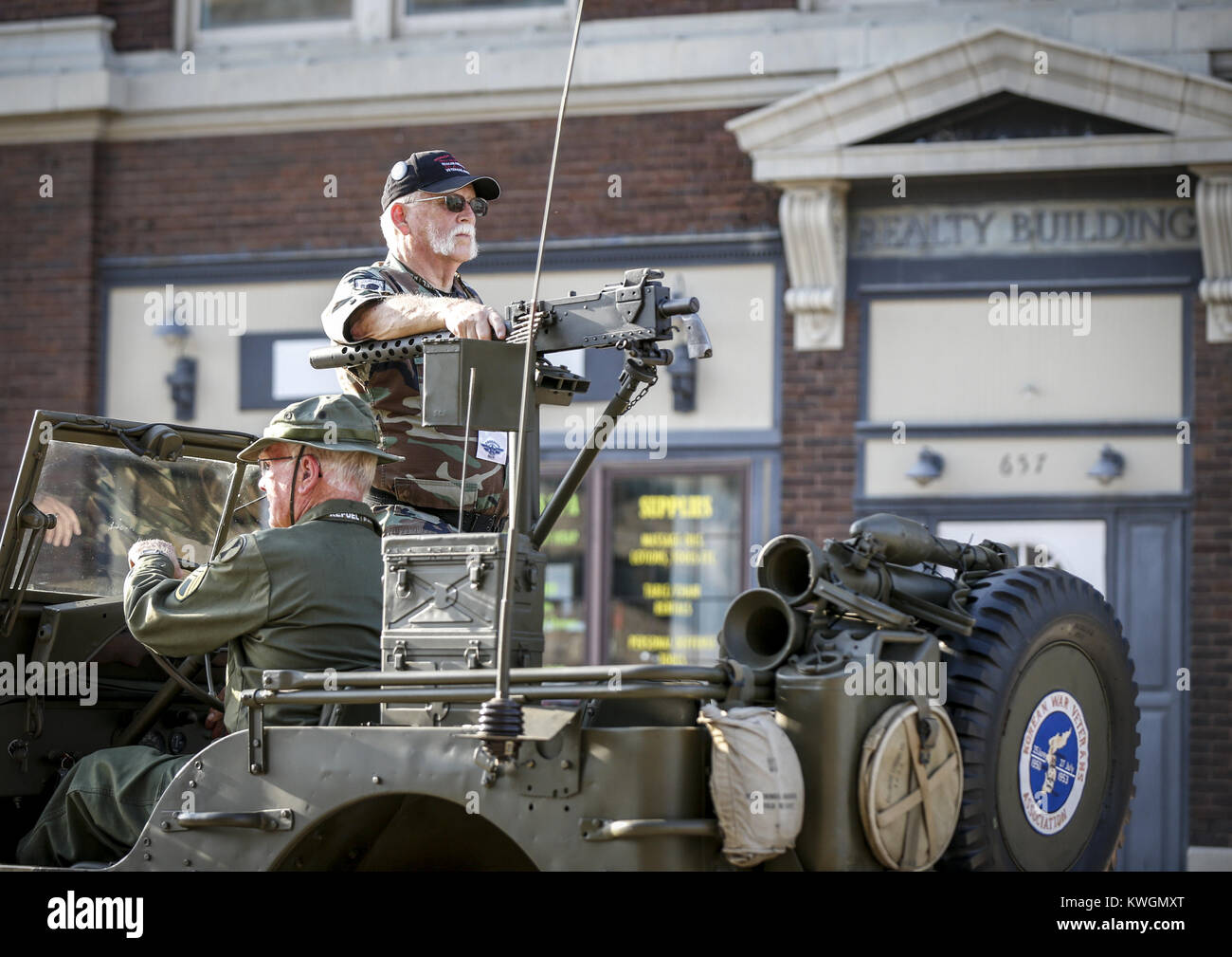 Davenport, Iowa, USA. Il 4° agosto 2016. Il Veterano dell'esercito Dennis Johnson sorge in corrispondenza della pistola di un 1945 di Willy Jeep pilotato da esercito veterano Robert Fitts in East Moline giovedì 4 agosto, 2016. La libertà eseguire 5k, che presentava un capretto ostacolo e un miglio di gara nonché il 5k stesso, si è svolta nel centro di East Moline come un vantaggio ai militari locali le famiglie. Credito: Andy Abeyta/Quad-City volte/ZUMA filo/Alamy Live News Foto Stock