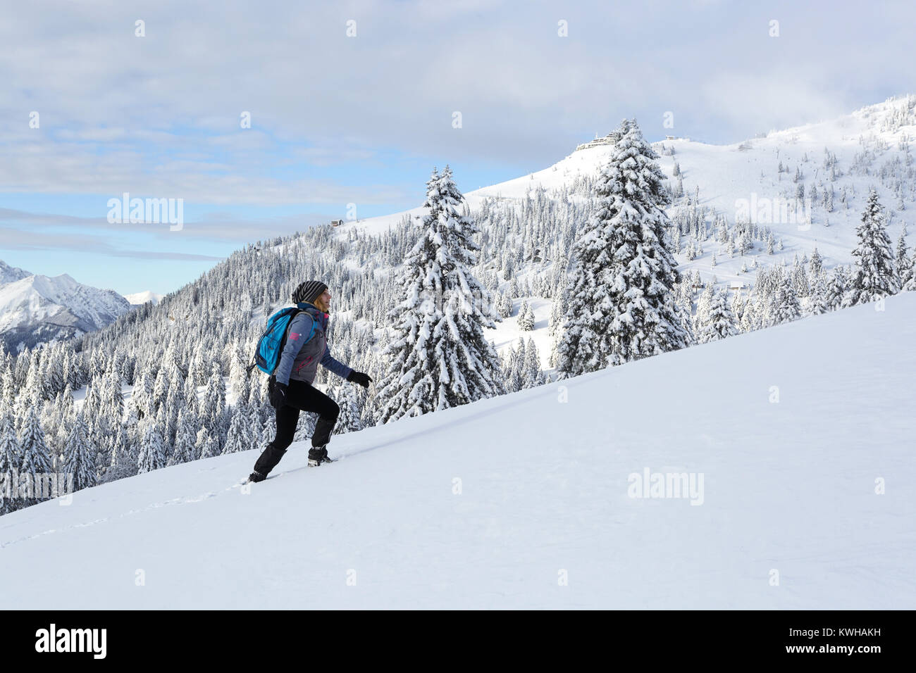 Donna in active vestito con uno zaino escursionismo in salita in condizioni  invernali su una montagna tra i pini coperti di neve, Krvavec, Slovenia  Foto stock - Alamy