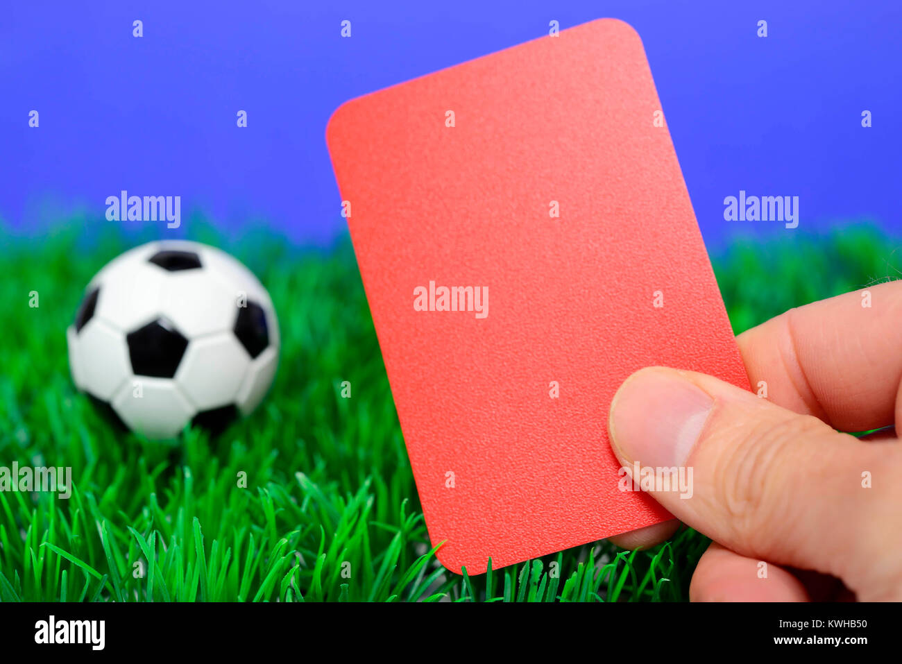 Il calcio in miniatura e la mano con mappa rosso, Fifa scandalo, MiniaturfuÃŸball und mano mit roter Karte, Fifa-Skandal Foto Stock