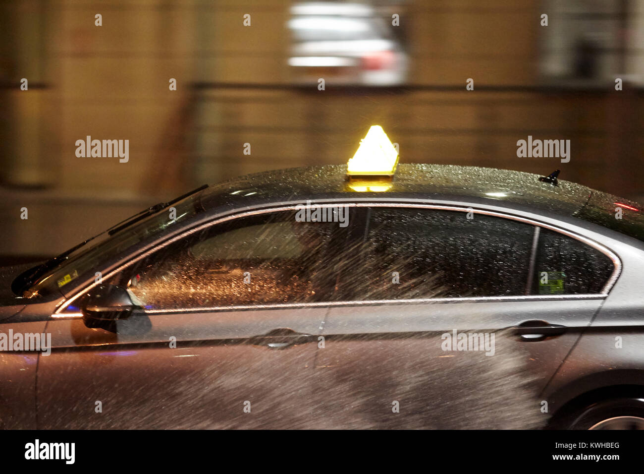 Taxi la guida rapidamente attraverso schizzi di acqua durante la tempesta a Belfast Irlanda del Nord Regno Unito Foto Stock