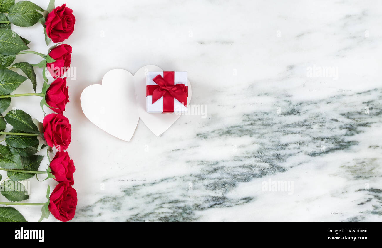 Single red rose con confezione regalo su scheda con pietra di marmo di sfondo piatto in vista dei laici Foto Stock
