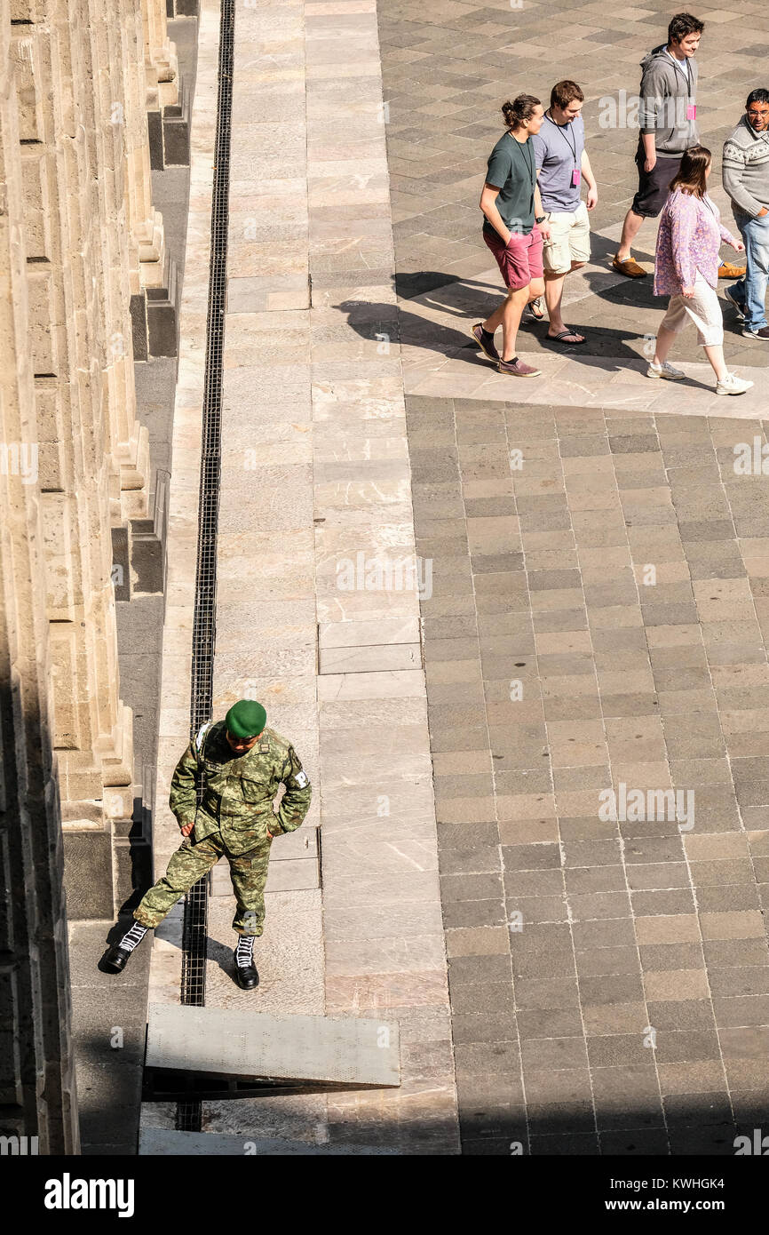 Un gruppo di turisti passa da un soldato a Plaza de la Costituzione in Città del Messico Foto Stock