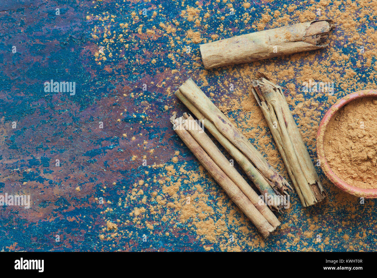 Cinnamomum verum. Bastoncini di cannella in polvere e sull'ardesia Foto Stock