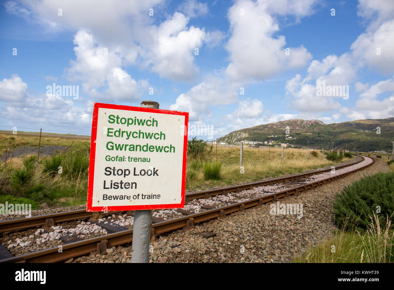 Smettere di guardare ascoltare un cartello di segnalazione con binario, Barmouth in distanza il Galles del Nord Regno Unito Foto Stock