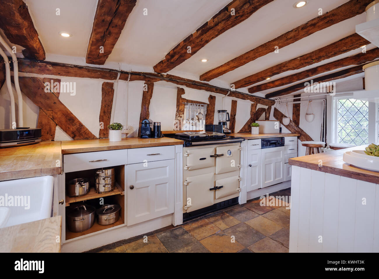 Fortemente cucina travi all'interno di un secolo XVI inglese cottage dotati  di stile tradizionale armadi, cassetti, forno e piano cottura con rovere  banconi e Foto stock - Alamy