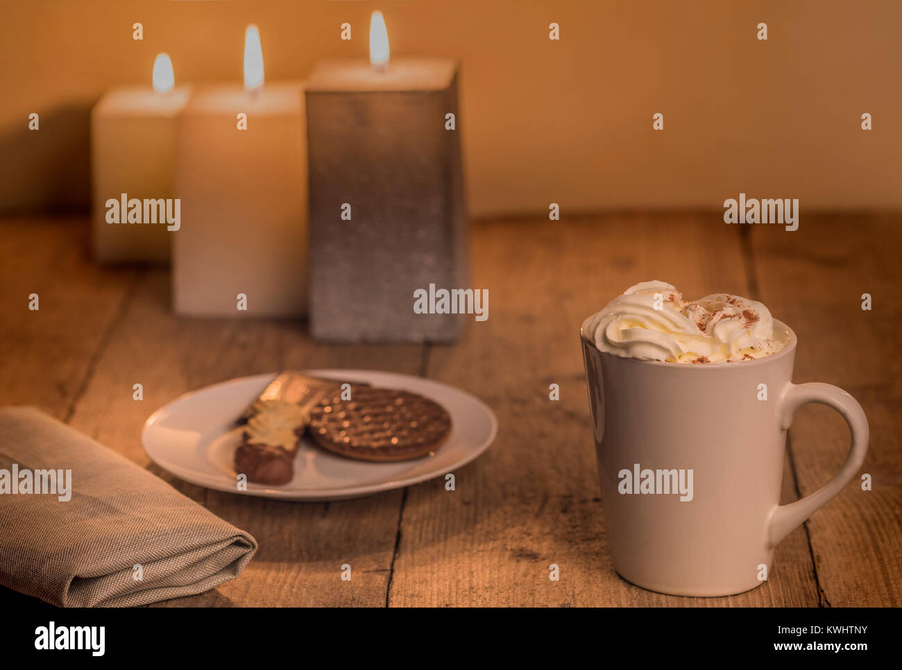 Calda e intima tavola a lume di candela con una tazza di crema di cioccolata calda. Foto Stock