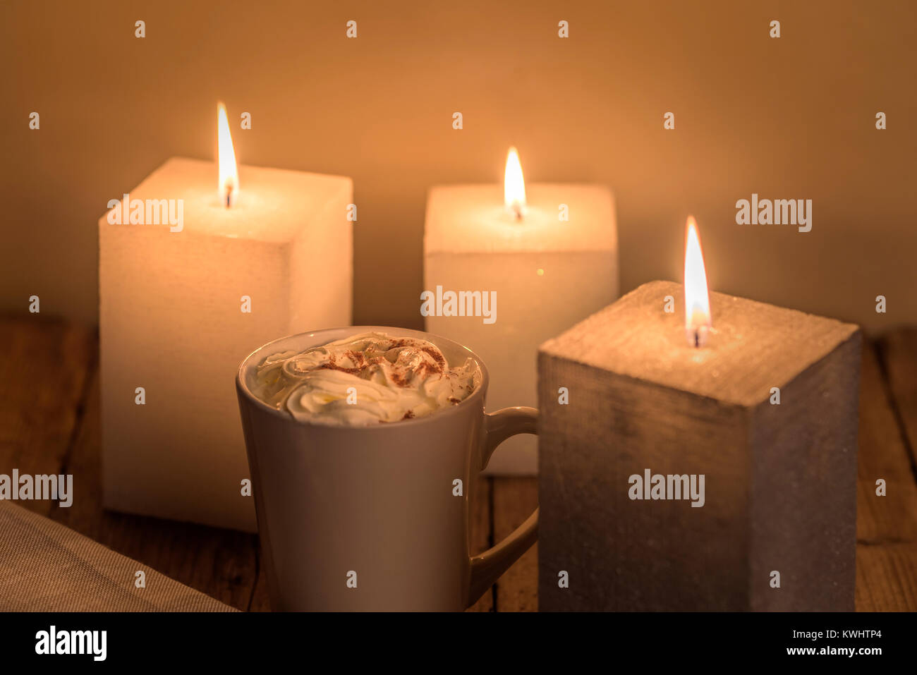 Calda e intima tavola a lume di candela con una tazza di crema di cioccolata calda. Foto Stock