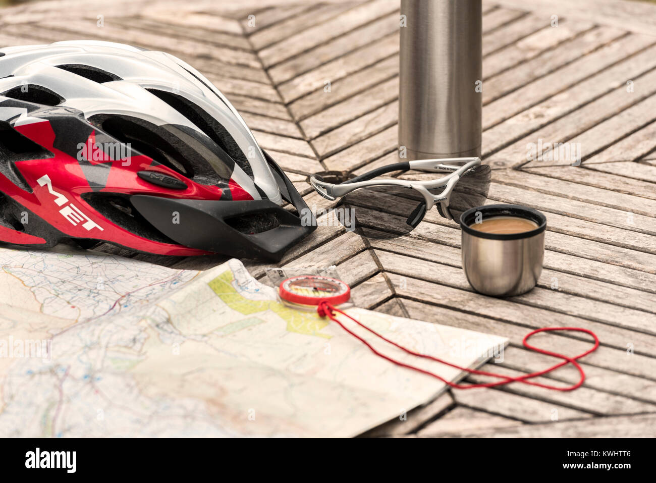 Ciclismo casco e bicchieri sul tavolo con pallone di caffè e la mappa. Foto Stock
