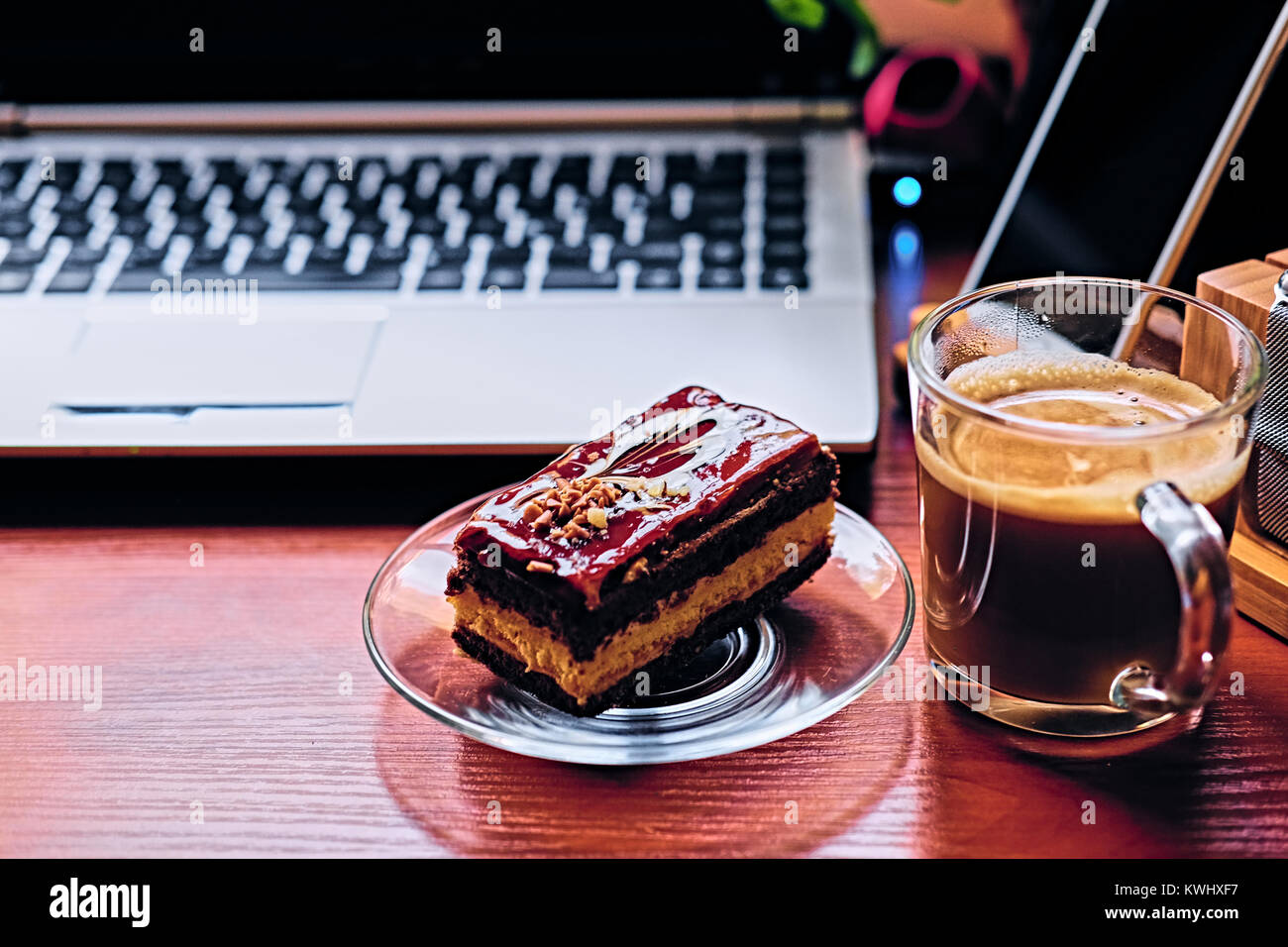 Torta dolce, una tazza di caffè su una tabella con smart watch, un laptop  Foto stock - Alamy