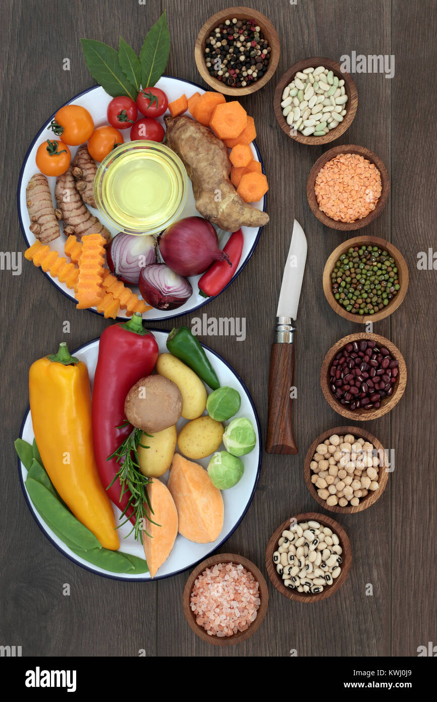 Mangiare sano concetto alimentare con erbe aromatiche, spezie, frutta, verdura e olio d'oliva e degli impulsi sul rovere rustico sfondo. Foto Stock
