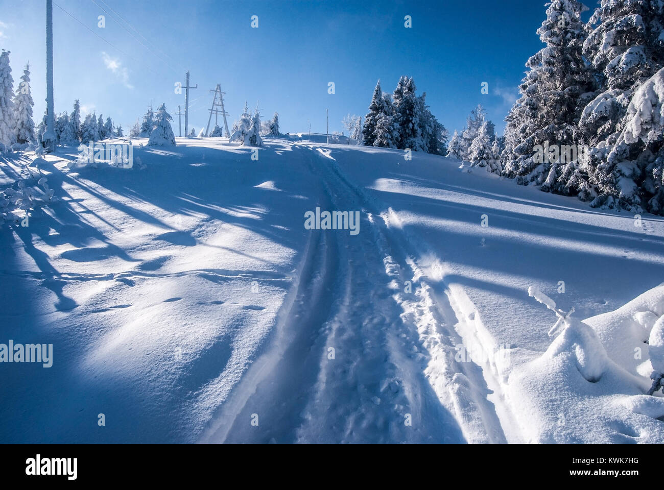 Paesaggio invernale con alberi congelati, neve, sentiero escursionistico,alimentazione torri e cielo blu vicino Wielka Racza hill in Zywiec Beskids montagne sul polacco - Lo slovacco Foto Stock