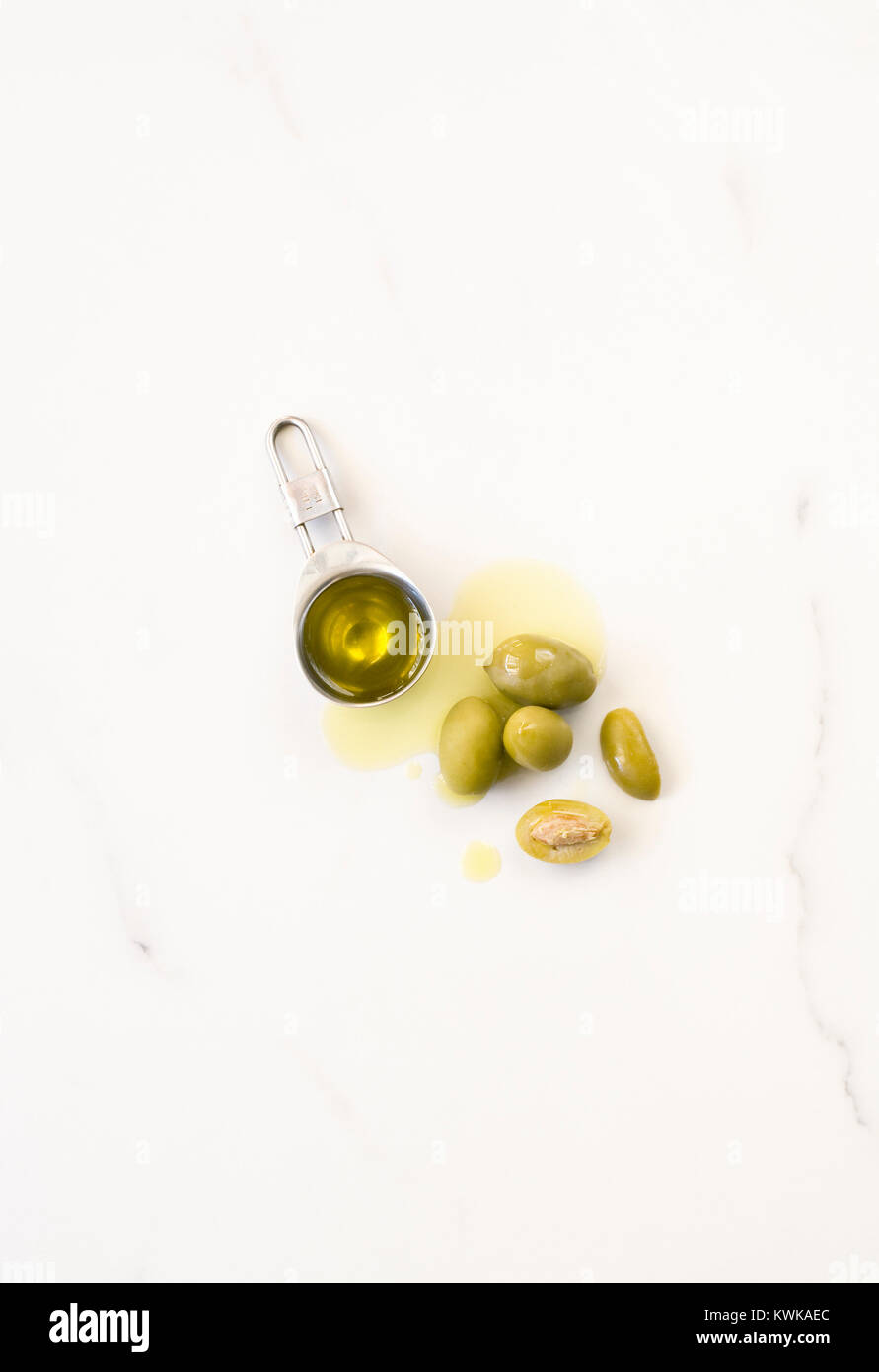 Olio di oliva e di olive su un piano di marmo. Foto Stock