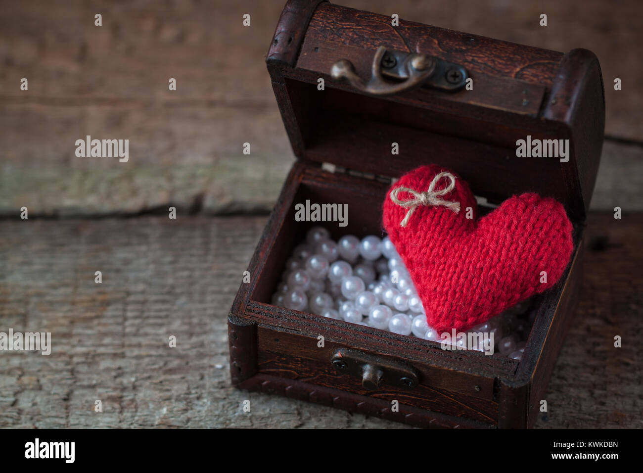 Cartolina con fatti a mano a maglia rosso Valentino di cuore in cassa di legno rustico sfondo. Tonica. Foto Stock