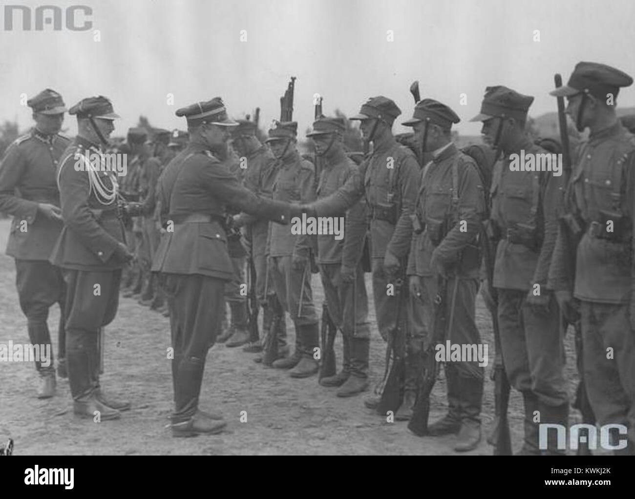 L'immagine mostra Zygmunt Čadek che fissa una medaglia sull'uniforme di un soldato durante una cerimonia di premiazione formale, riflettendo le pratiche d'onore militari. Foto Stock