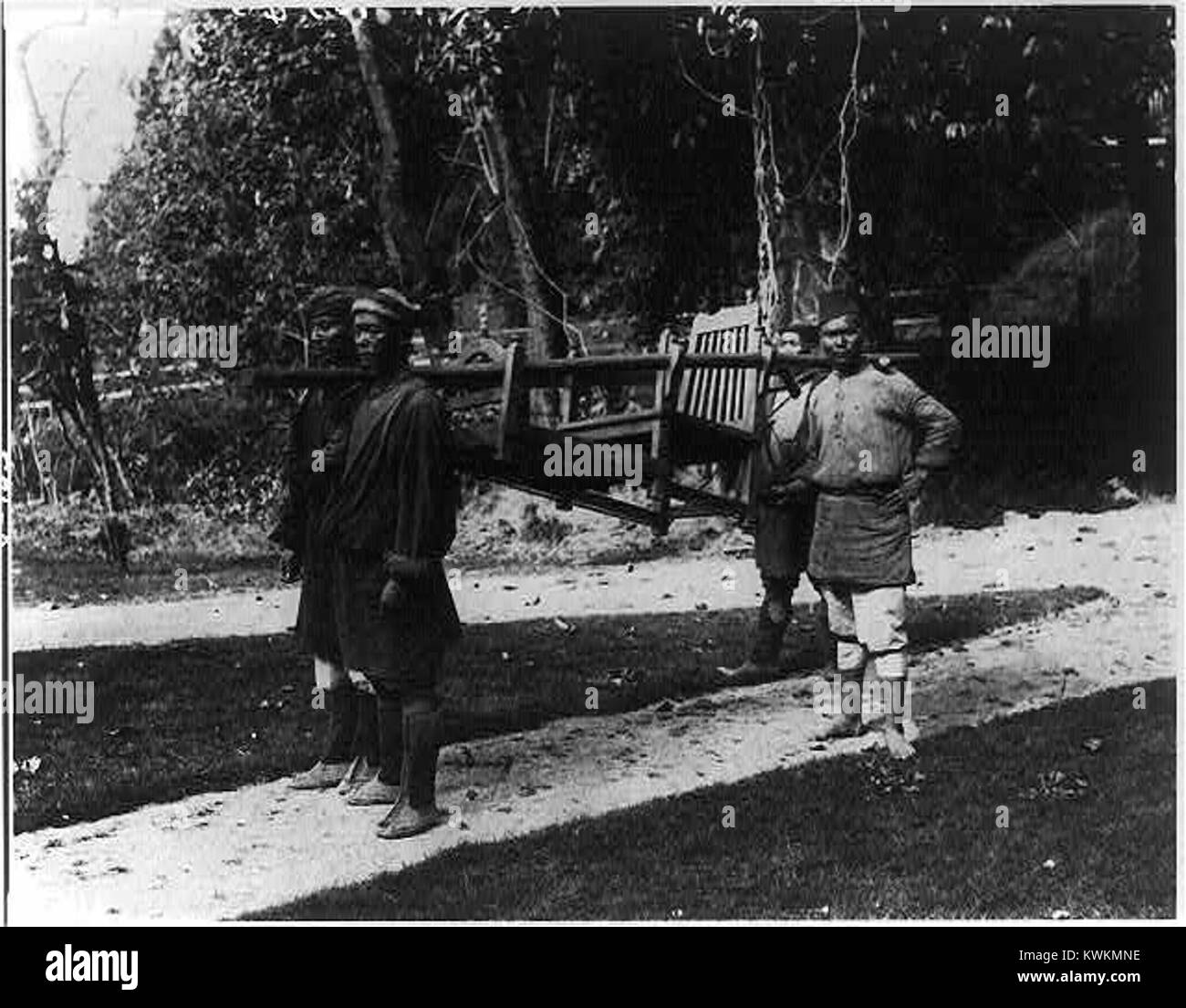 Una foto di un 'dandy', una sedia berlina usata nell'India coloniale, con portatori a Darjeeling, che riflette il trasporto coloniale e lo stile di vita nei primi anni '1900 Foto Stock