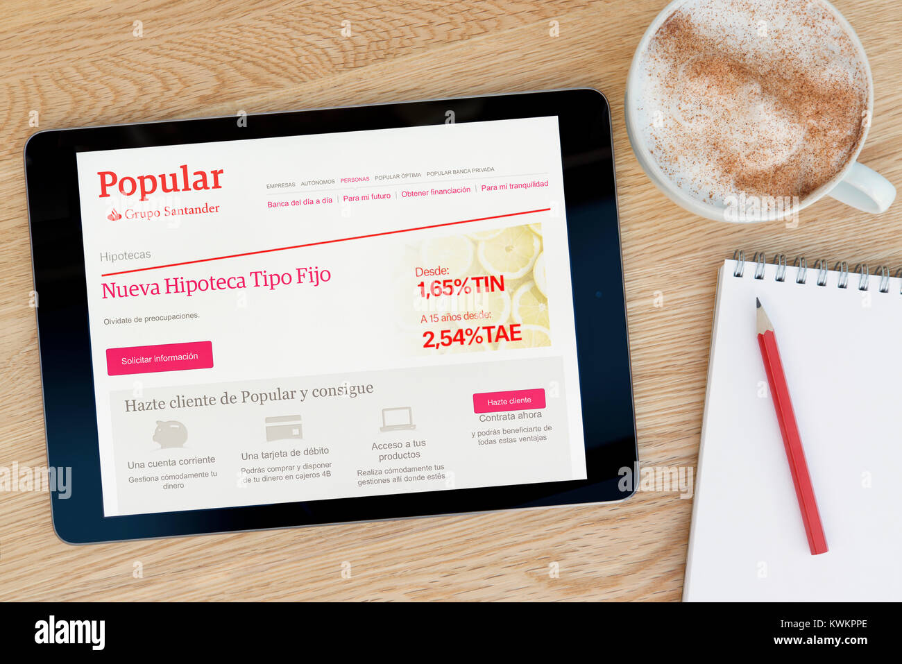 La Banca popolare sito web su un iPad dispositivo tablet, appoggiato su un tavolo di legno accanto a un blocco note, matita e tazza di caffè (editoriale solo) Foto Stock