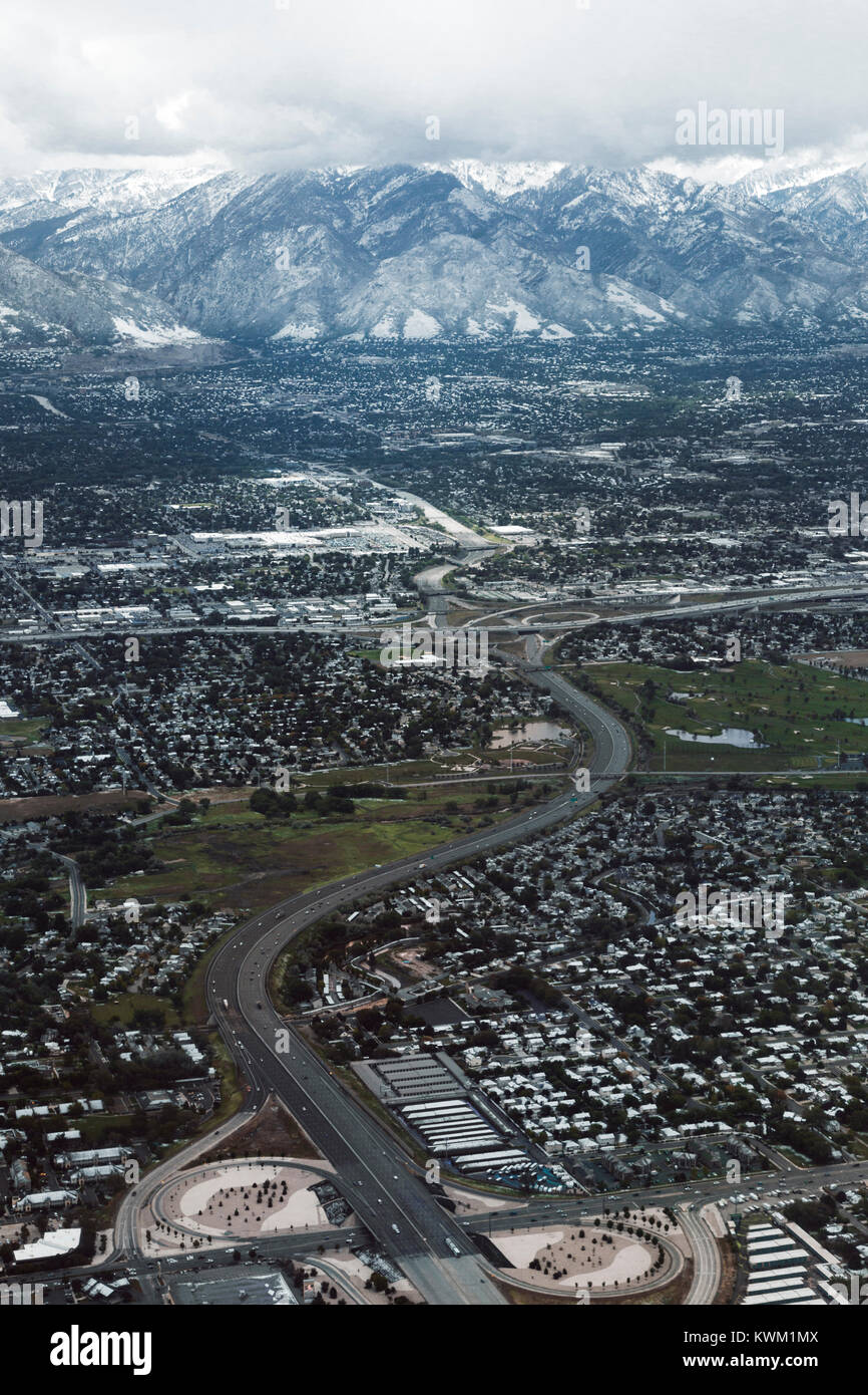 Vista aerea del paesaggio urbano contro montagne dalle vette innevate Foto Stock