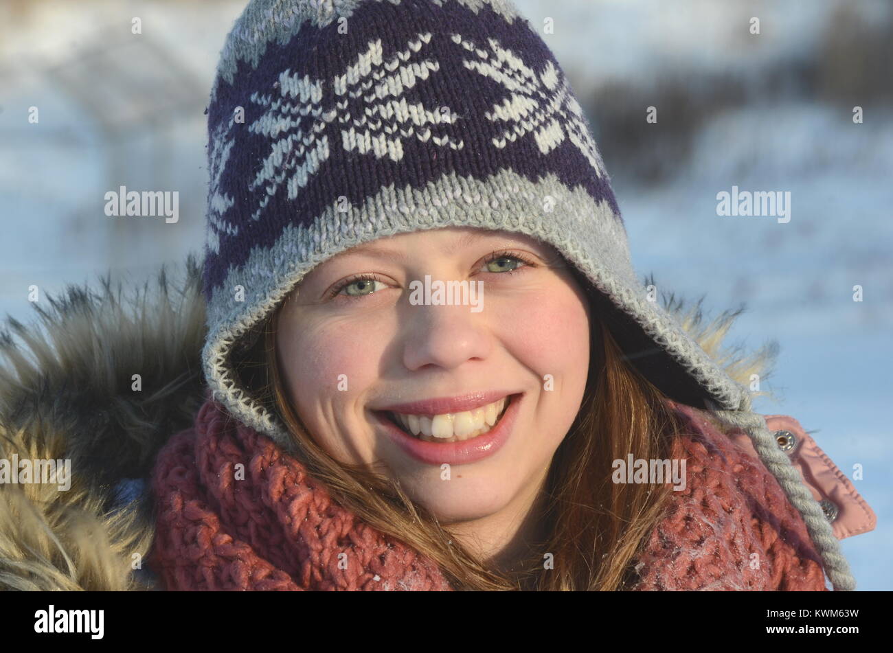 Ritratto di un bellissimo caucasico sorridente ragazza adolescente su un nevoso inverno sfondo. Inverno freddo in Canada. Una giovane donna orientale di origine europea. Foto Stock