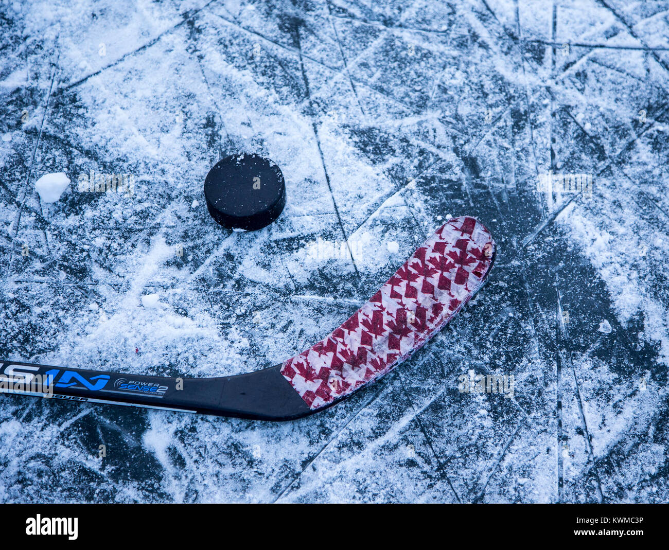 Bastone di hockey e puck su un laghetto ghiacciato Foto Stock