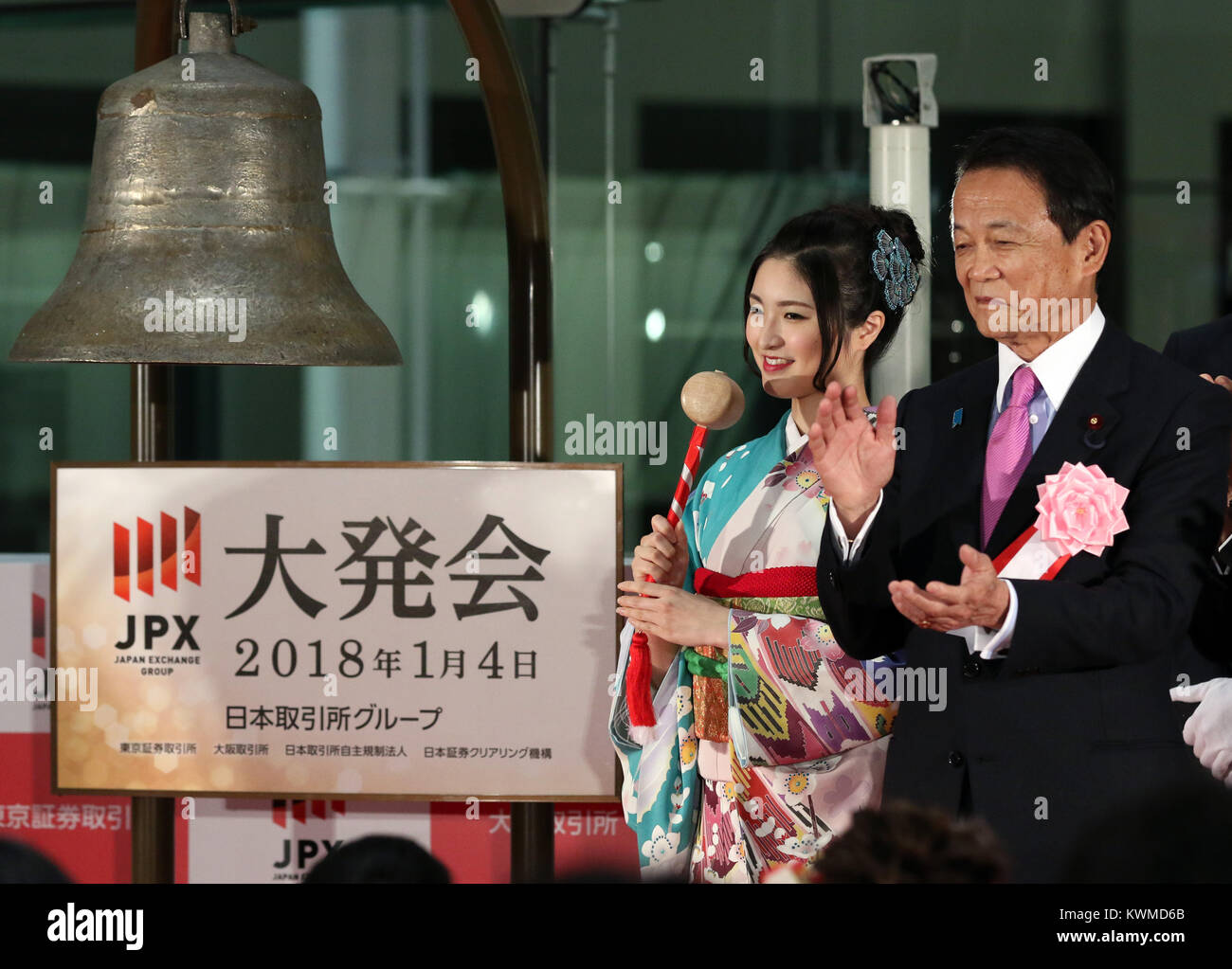 Tokyo, Giappone. 4 gennaio, 2018. Una donna in kimono suona il campanello mentre il Ministro delle finanze giapponese Taro Aso (R) tubicini mani durante una cerimonia organizzata per celebrare il primo giorno di negoziazione del 2018 presso la Borsa di Tokyo giovedì 4 gennaio, 2018. La quota del Giappone è prezzi saltato 561.12 yen per chiudere a 23,326.06 yen presso la sessione mattutina della Borsa di Tokyo. Credito: Yoshio Tsunoda/AFLO/Alamy Live News Foto Stock