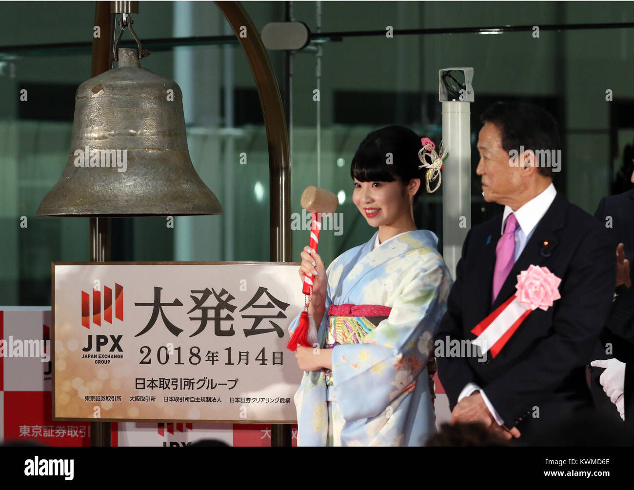 Tokyo, Giappone. 4 gennaio, 2018. Una donna in kimono anelli la palla mentre il Ministro delle finanze giapponese Taro Aso (R) si affaccia su durante una cerimonia organizzata per celebrare il primo giorno di negoziazione del 2018 presso la Borsa di Tokyo giovedì 4 gennaio, 2018. La quota del Giappone è prezzi saltato 561.12 yen per chiudere a 23,326.06 yen presso la sessione mattutina della Borsa di Tokyo. Credito: Yoshio Tsunoda/AFLO/Alamy Live News Foto Stock