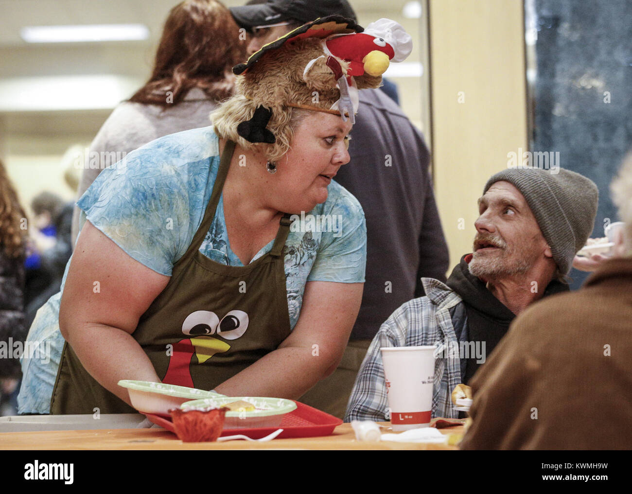 Moline, Iowa, USA. 24 Novembre, 2016. Volunteer Kristy VanDerGejuchte di Milano controlli a Michael Berry dell isola di roccia durante il suo pasto a SouthPark mall di Moline, giovedì 24 novembre, 2016. Il sig. ringraziamento ha tenuto il suo 46th annuale cena comunitaria con l'aiuto di circa 400 volontari per servire oltre 2.000 ospiti. Credito: Andy Abeyta/Quad-City volte/ZUMA filo/Alamy Live News Foto Stock