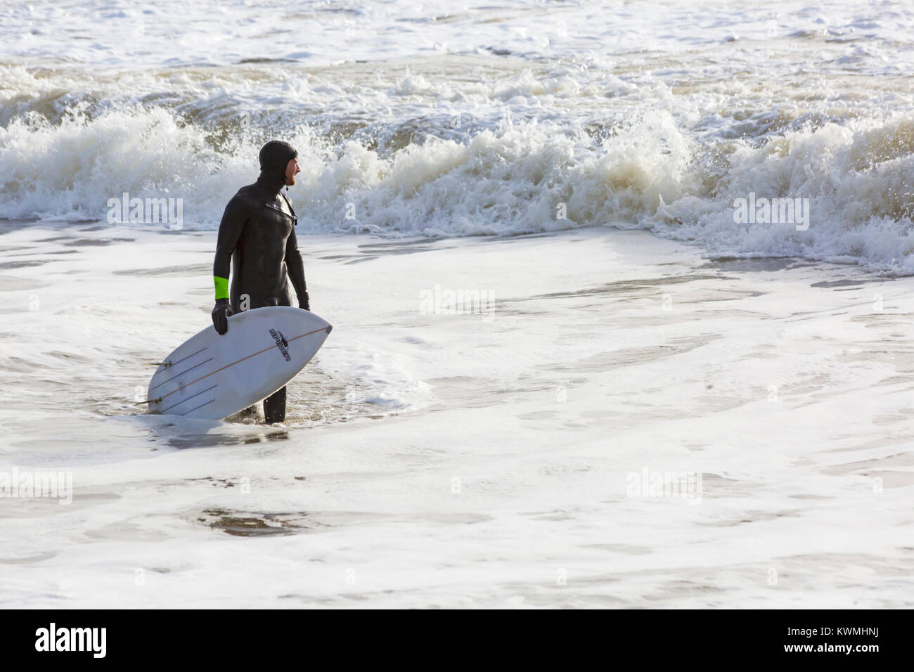 Bournemouth Dorset, England Regno Unito. 4 gennaio, 2018. Regno Unito: meteo surfer tenendo la tavola da surf nel mare godendo il surf in una giornata ventosa a Bournemouth Beach, come i surfisti a effettuare la maggior parte delle condizioni di vento e grandi onde. Credito: Carolyn Jenkins/Alamy Live News Foto Stock