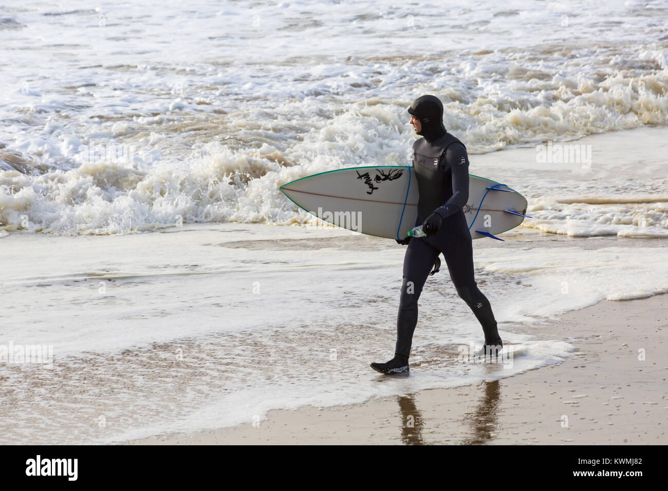 Bournemouth Dorset, England Regno Unito. 4 gennaio, 2018. Regno Unito: meteo surfer tenendo la tavola da surf, voce nel mare per godere il surf in una giornata ventosa a Bournemouth Beach, come i surfisti a effettuare la maggior parte delle condizioni di vento e grandi onde. Credito: Carolyn Jenkins/Alamy Live News Foto Stock