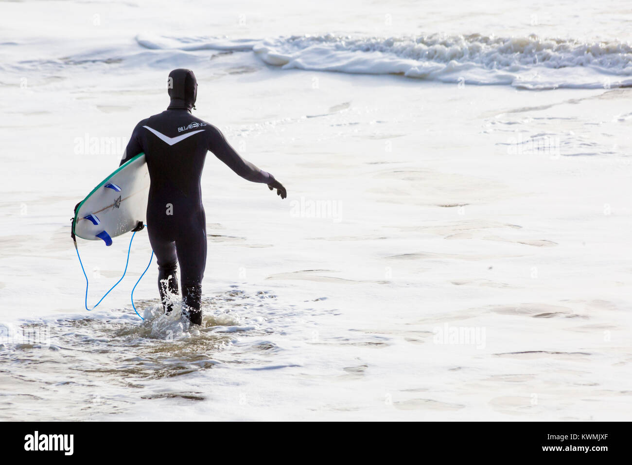 Bournemouth Dorset, England Regno Unito. 4 gennaio, 2018. Regno Unito: meteo surfer tenendo la tavola da surf, voce nel mare per godere il surf in una giornata ventosa a Bournemouth Beach, come i surfisti a effettuare la maggior parte delle condizioni di vento e grandi onde. Foto Stock
