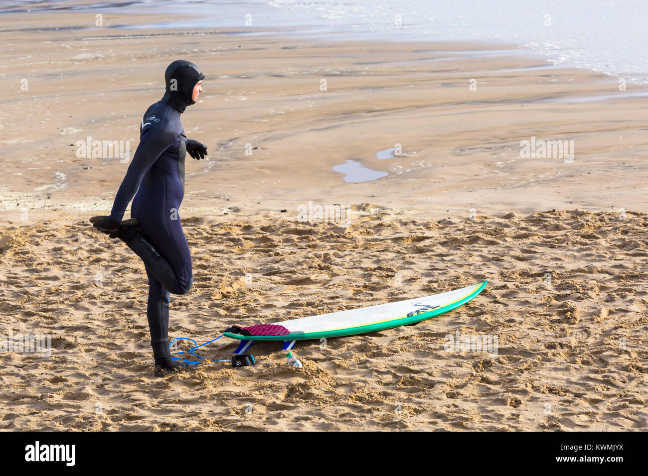 Bournemouth Dorset, Regno Unito. 4 gennaio, 2018. Regno Unito meteo: giornata di vento a Bournemouth. Surfer facendo warm up esercizi sulla spiaggia Foto Stock