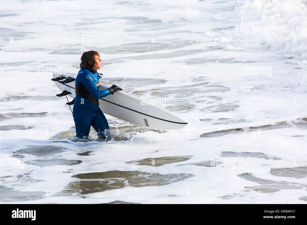 Bournemouth Dorset, England Regno Unito. 4 gennaio, 2018. Regno Unito: meteo surfer tenendo la tavola da surf, voce nel mare per godere il surf in una giornata ventosa a Bournemouth Beach, come i surfisti a effettuare la maggior parte delle condizioni di vento e grandi onde. Foto Stock