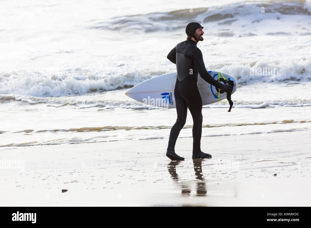 Bournemouth Dorset, England Regno Unito. 4 gennaio, 2018. Regno Unito: meteo surfer tenendo la tavola da surf in mare per godere il surf in una giornata ventosa a Bournemouth Beach, come i surfisti a effettuare la maggior parte delle condizioni di vento e onde grandi Foto Stock