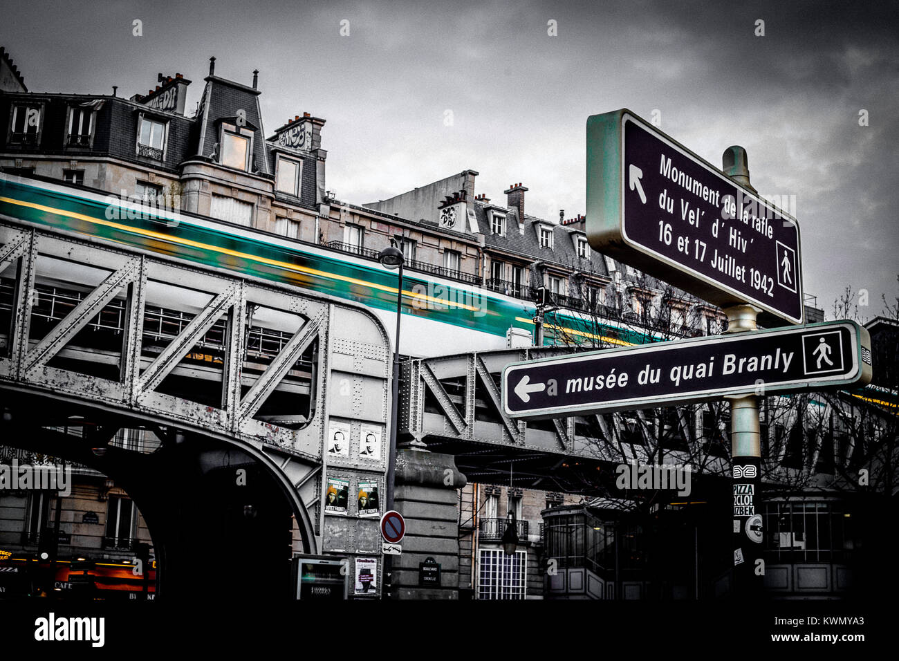 A basso angolo di visione del vecchio ponte della ferrovia nei confronti di vecchi edifici residenziali nel centro cittadino di Parigi in un giorno nuvoloso Foto Stock