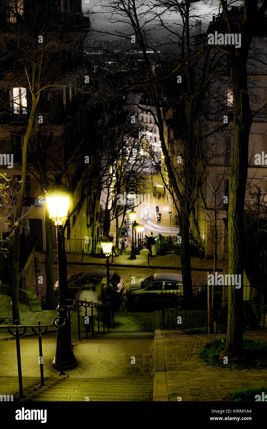 Visualizza in basso dei gradini ripidi sul pendio di una collina in una città di notte illuminato con luci di strada e un viale di nuda alberi sfrondato in inverno con case a schiera di un Foto Stock