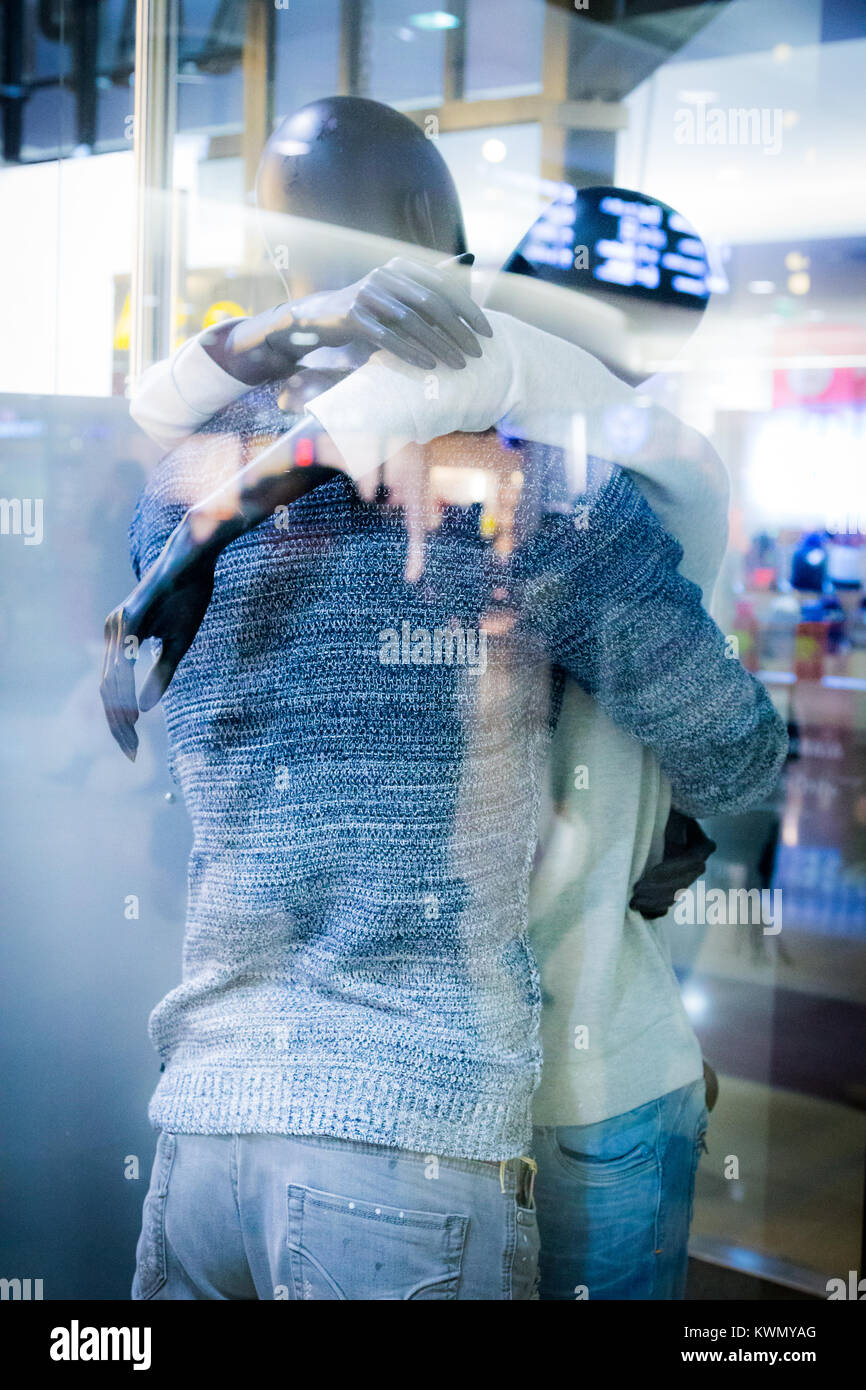Coppia giovane in amore abbracciando all'arrivo o di partenza in un moderno aeroporto internazionale Foto Stock