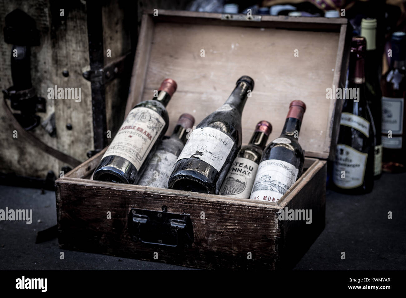 Close-up di diverse bottiglie etichettate di vino in un aperto vintage scatola in legno conservati nella cantina di invecchiamento Foto Stock